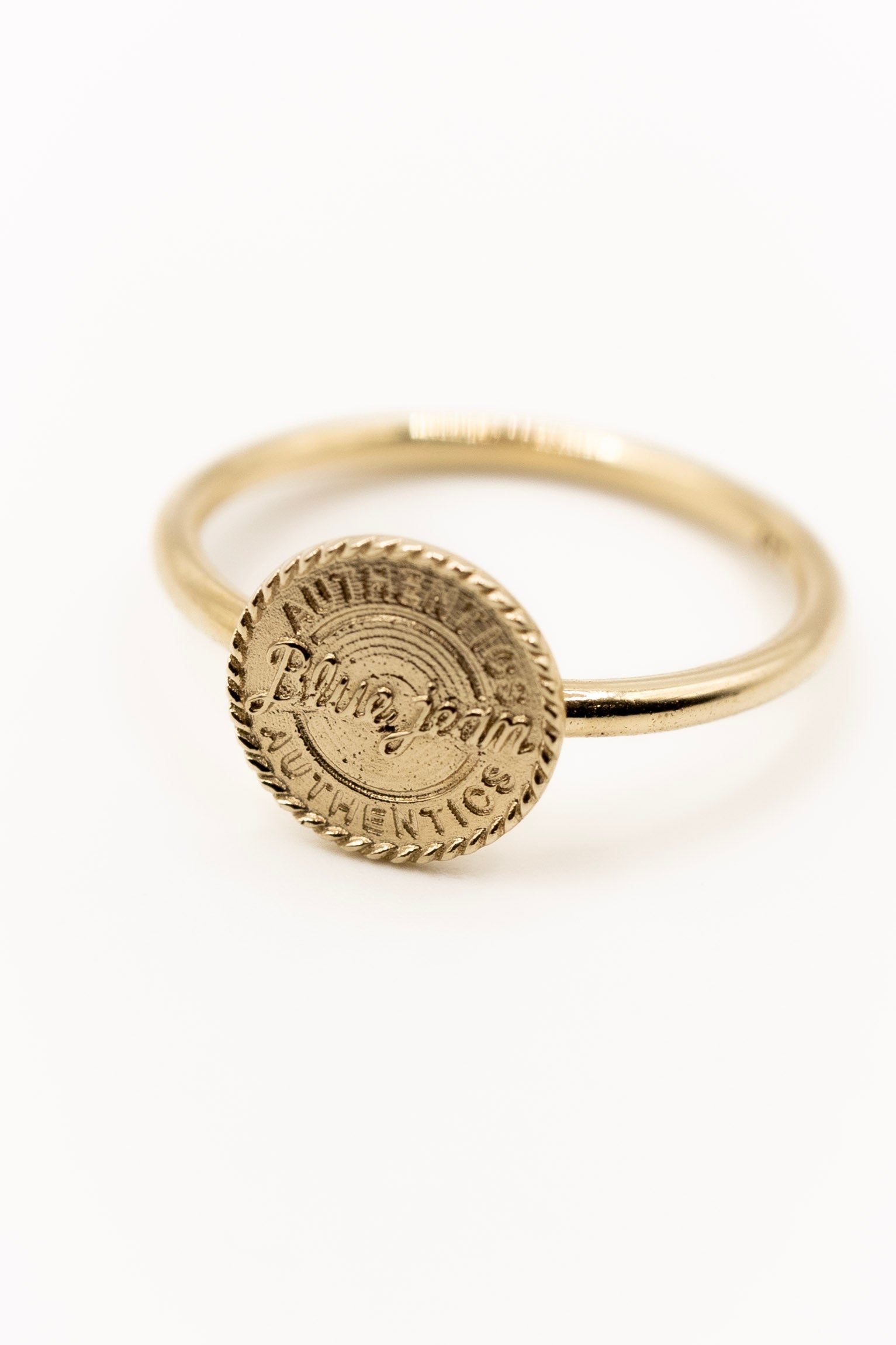Gold ring with a circular design on a white background
