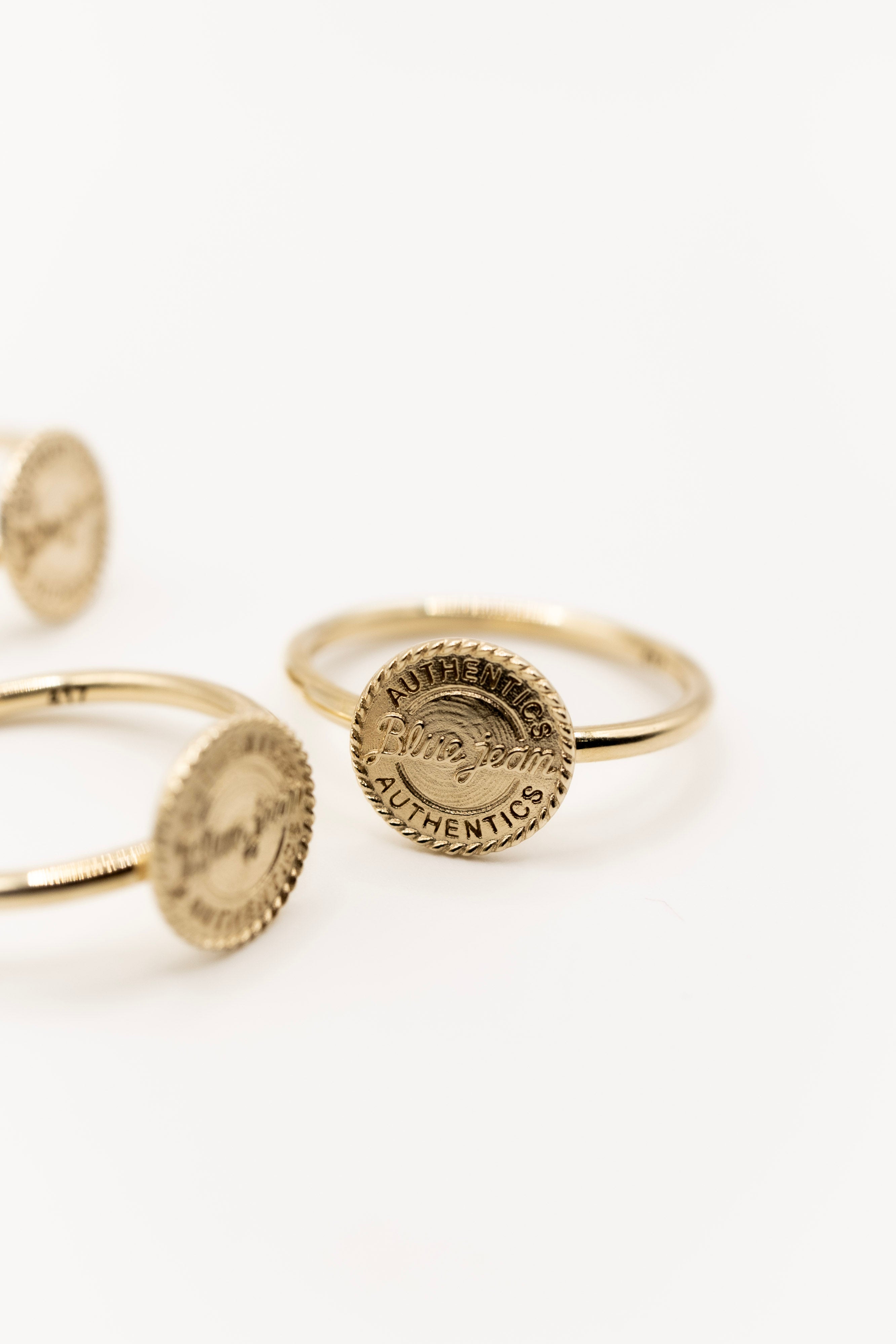 Solid Gold Cowboy inspired rings with circular designs on a white background