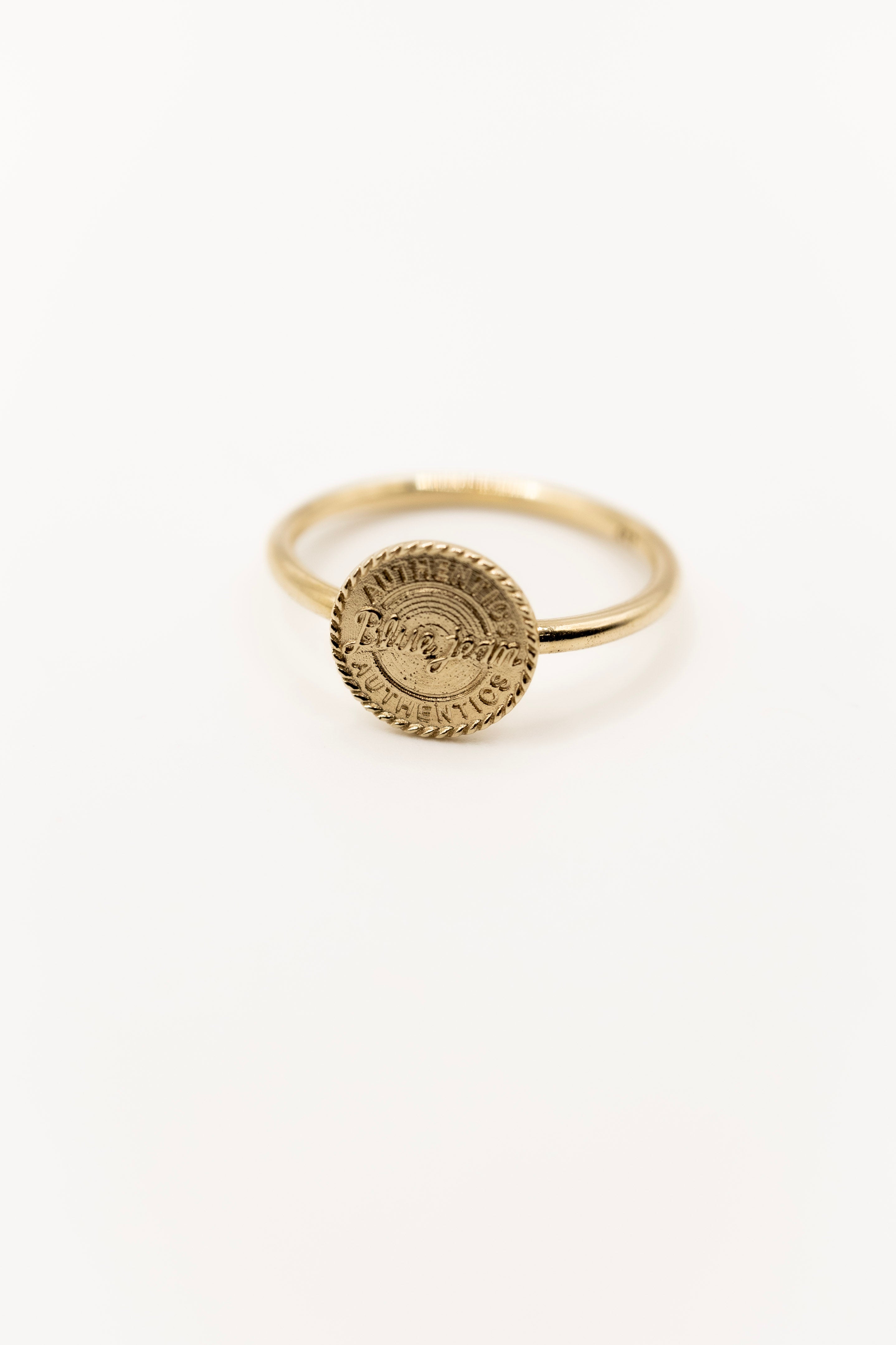 Gold ring with a circular design on a white background