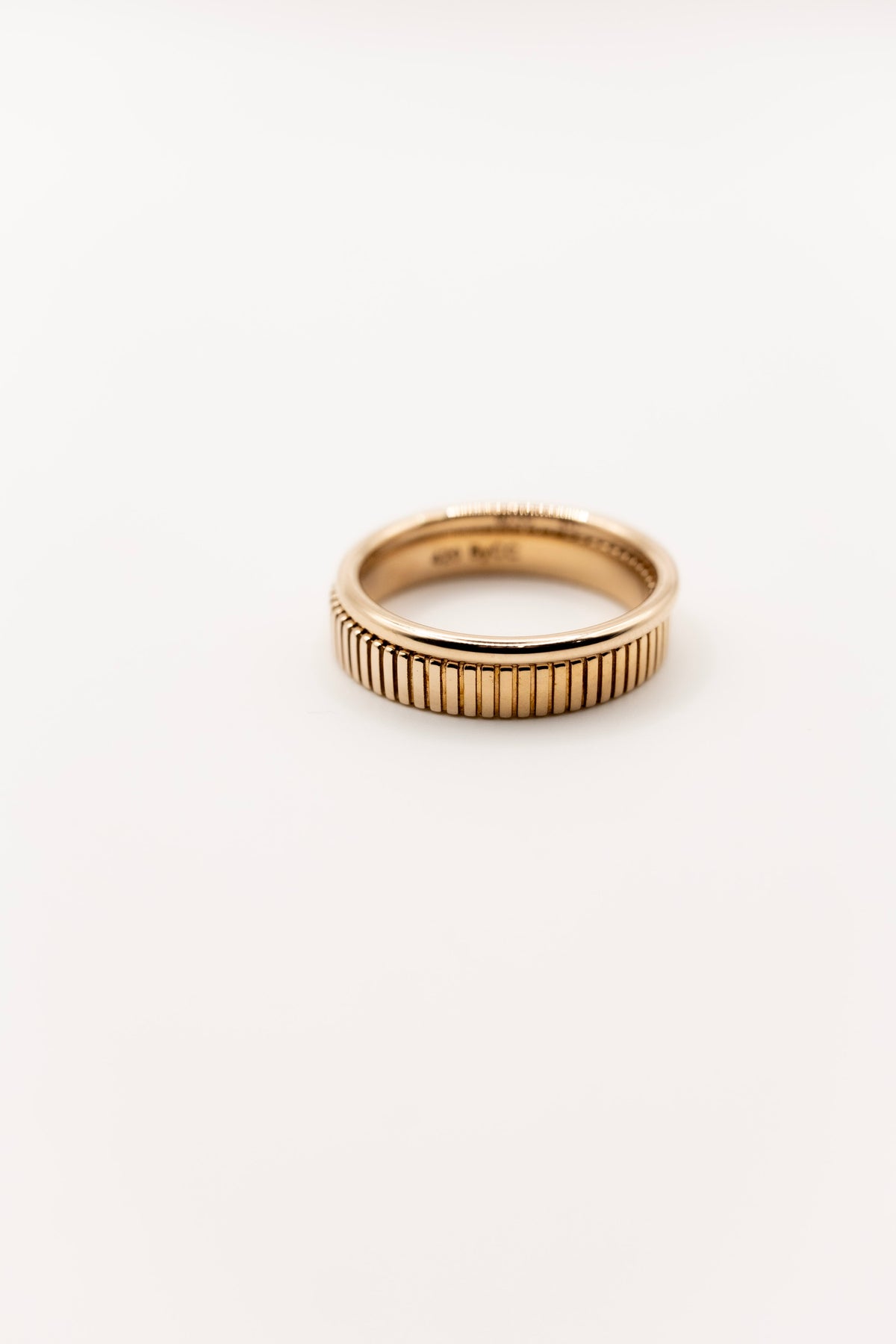 Gold textured band stacked with plain band on a white background