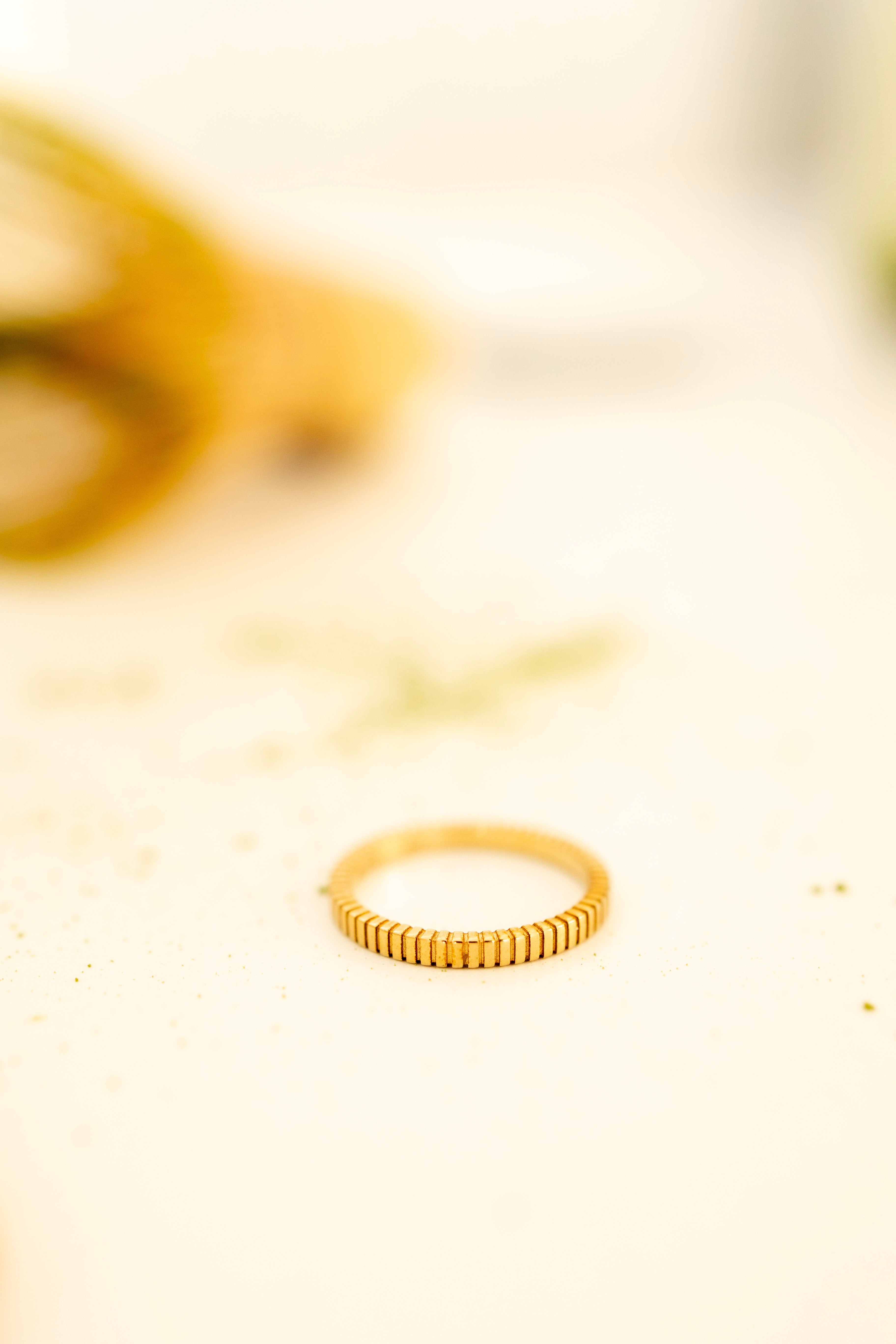 Gold ring on a light beige background