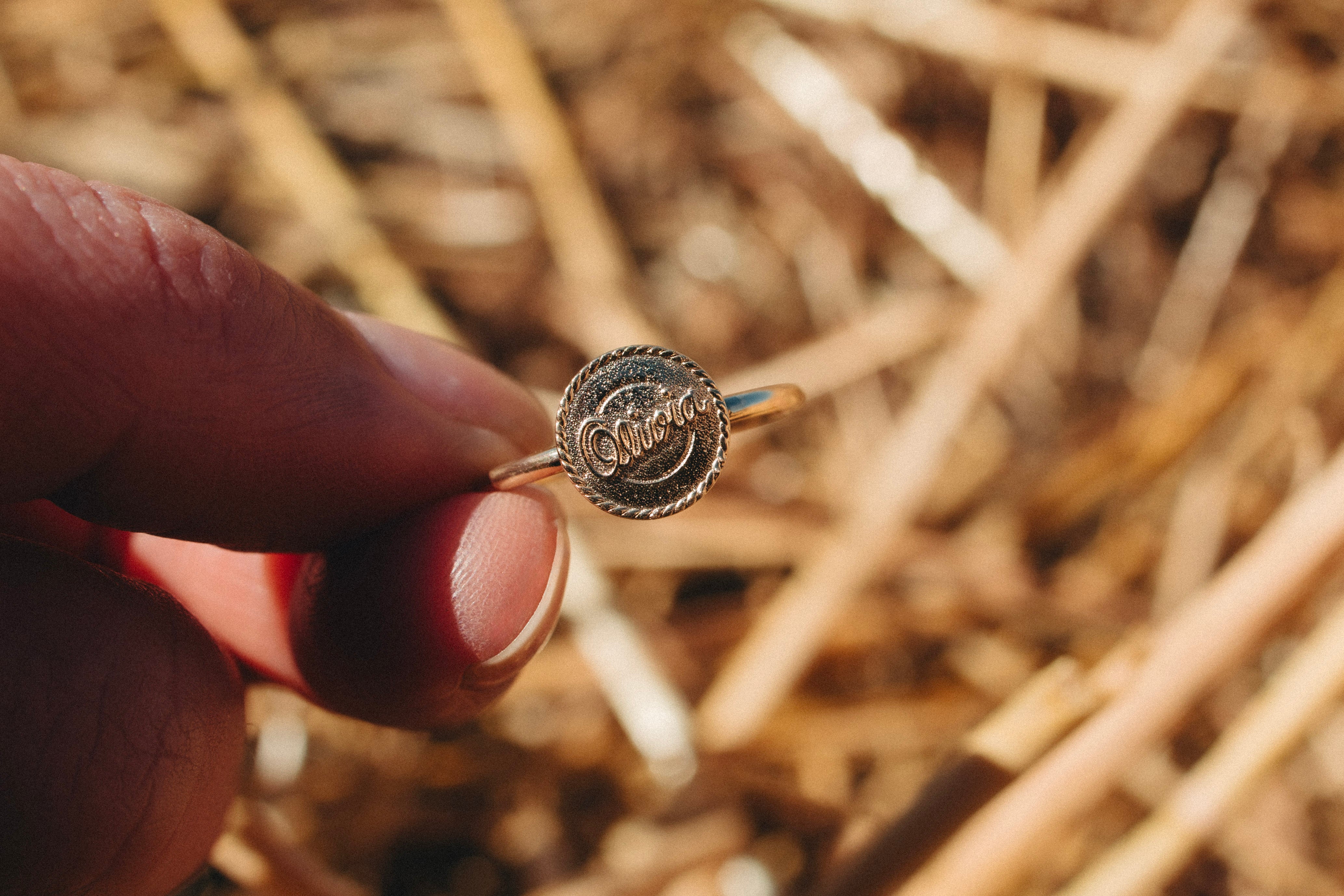 Close-up of a solid gold signet ring worn in spring light during a regional NSW shoot.