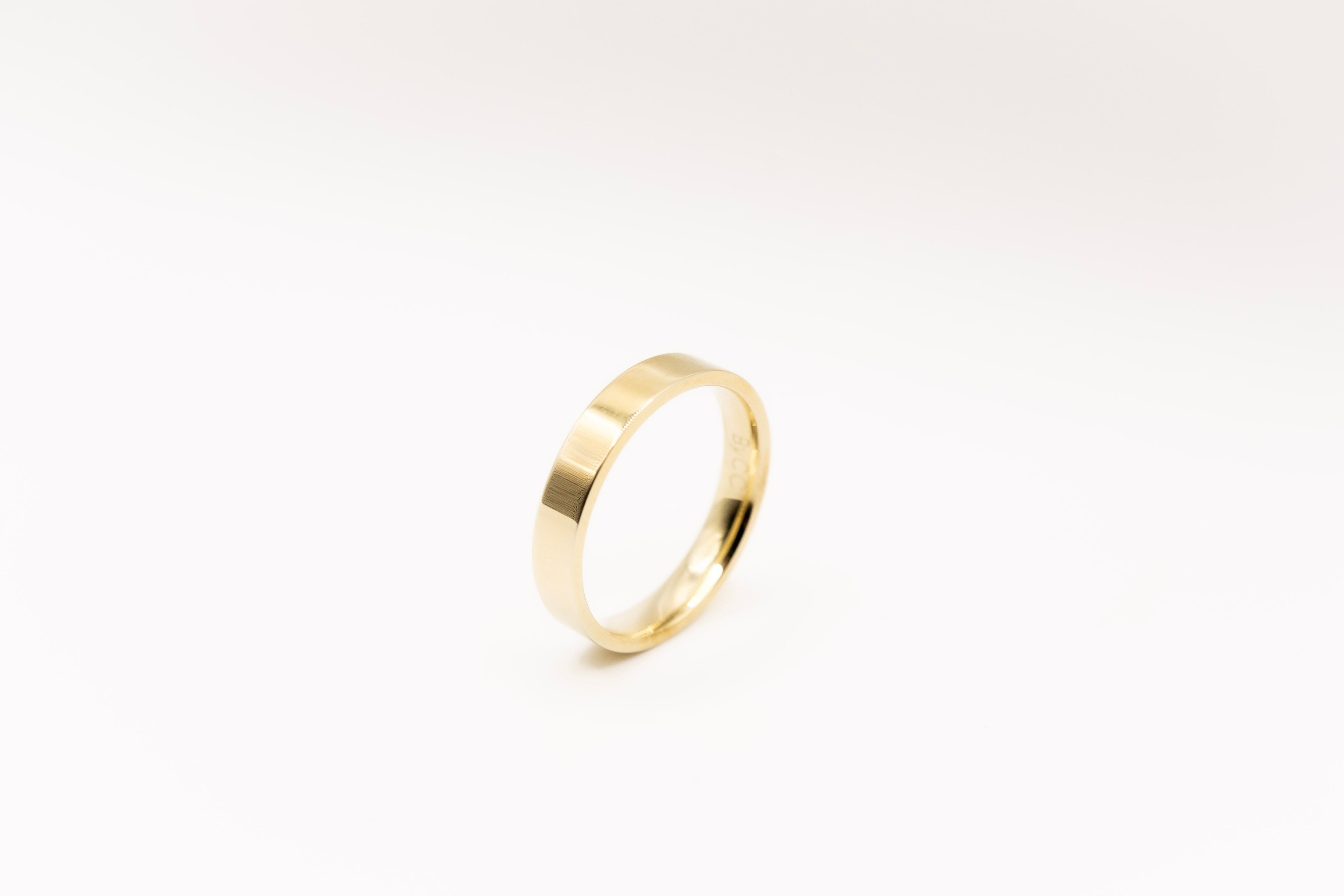 Gold band ring on a white background