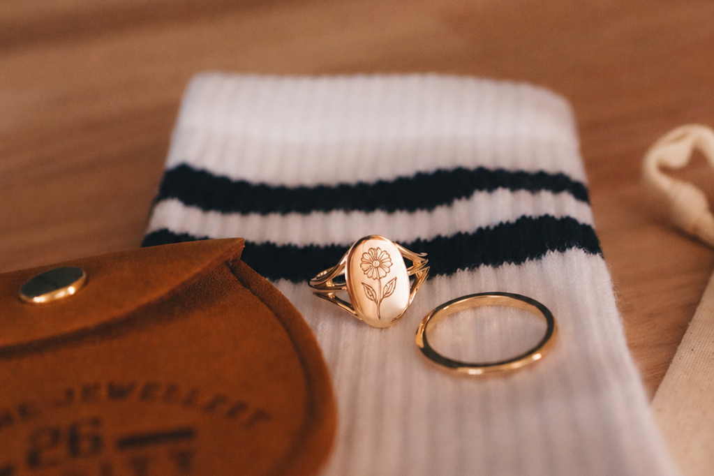 Gold rings on a white sock with black stripes on a wooden surface