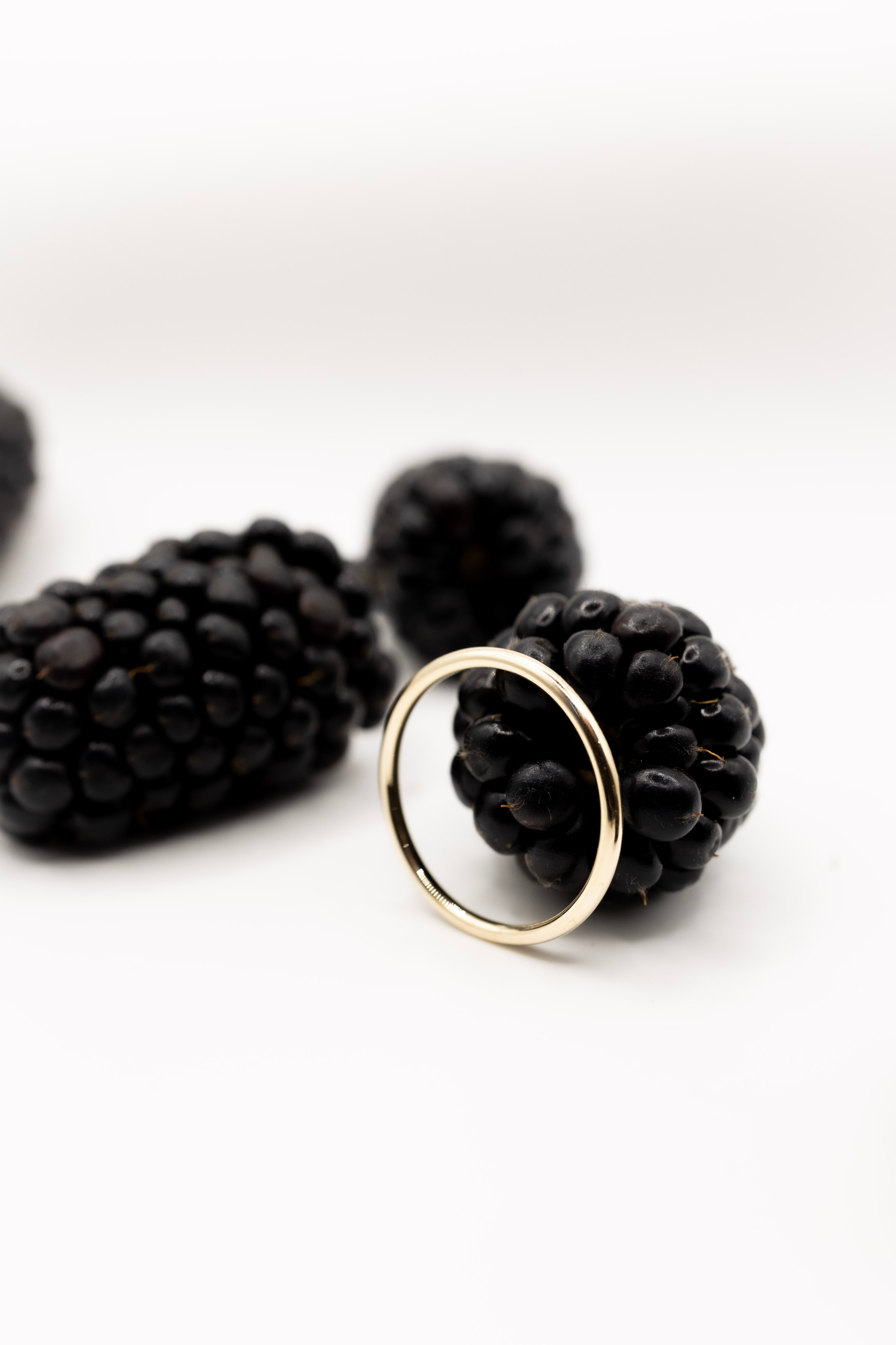 Black berry with a gold ring on a white background