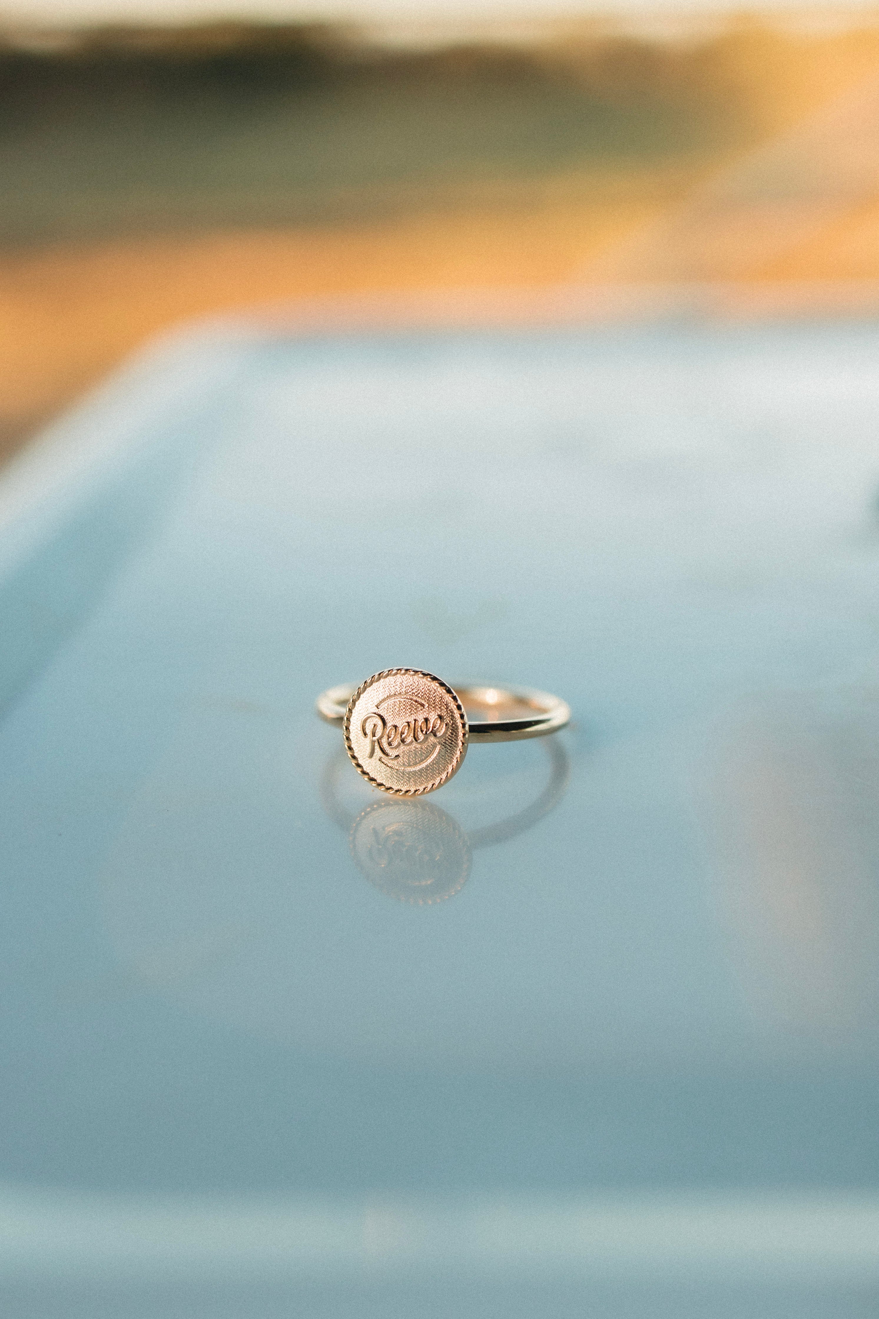 Close-up flat lay of Signet solid gold ring, highlighting simple, timeless design.